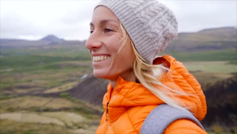 Slow-motion-video-of-young-woman-hiking-in-Iceland-on-top-of-volcanic-crater,-happiness-in-nature,-caucasian-female-smiling-and-enjoying-life.-People-discovery-concept