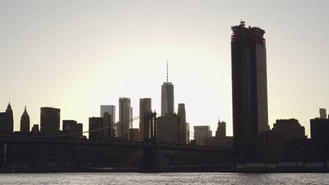 A-view-of-Lower-Manhattan-skyline-and-Brooklyn-Bridge-in-New-York,-United-States-in-sunset-filmed-from-the-East-River