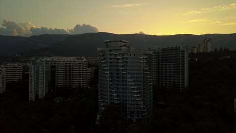 neue-moderne-Mehrfamilienhaus-Wolkenkratzer-in-Stadt-Luftbild-Panoramablick-auf-die-Berge