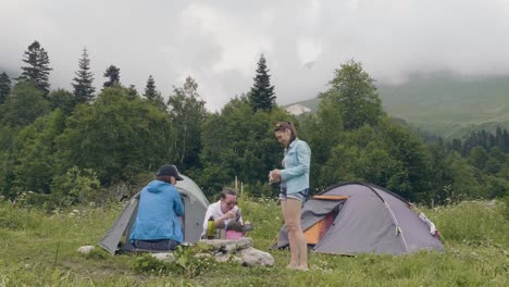 Amigos-descansando-en-el-camping-de-verano.-Gente-descansando-junto-a-la-tienda-de-campaña-en-el-bosque