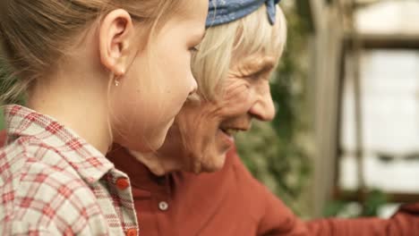 Ältere-Frau-und-kleine-Mädchen,-die-Arbeit-im-Garten