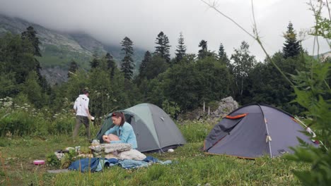 Pareja-de-turistas-en-tienda-de-campaña-en-paisaje-de-montaña