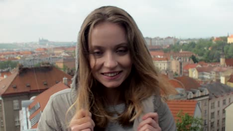 junge-Frau-sucht-auf-Prag-Panorama,-mit-Blick-auf-die-Kamera-und-lächelnd