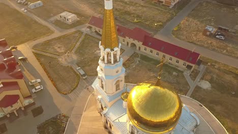 Aerial-Nahaufnahme-Religion-Kreuz-auf-erstaunliche-golden-Kirchenarchitektur-während-des-Sonnenuntergangs