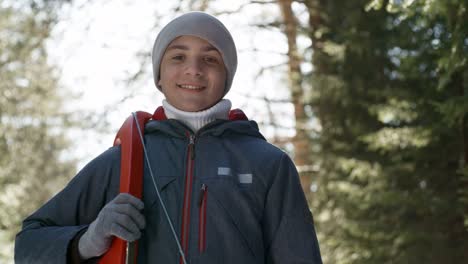 Friendly-Boy-Holding-Sled-and-Smiling