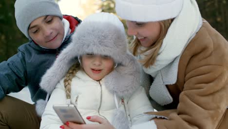 Mutter-und-Kinder-anzeigen-von-Fotos-auf-Smartphone