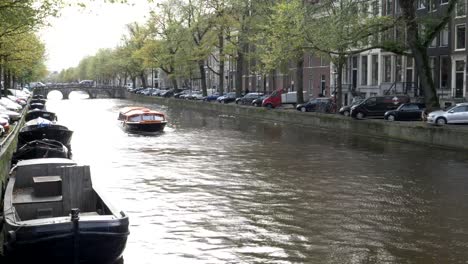 am-Nachmittag-Blick-auf-eine-Sonne-beleuchtet,-Kanal-und-einem-Ausflugsboot-in-amsterdam