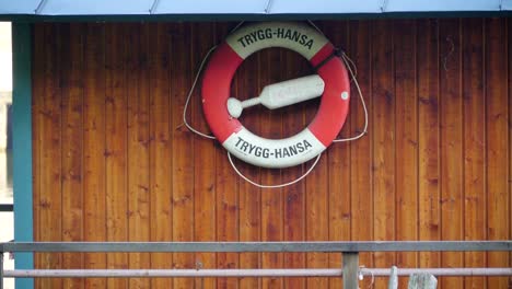 Eine-rote-und-weiße-Ring-Bouy-hängt-an-der-Wand-in-Stockholm-Schweden