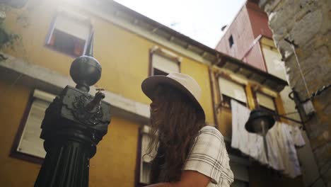 Smiling-woman-wetting-hands-in-street-fountain