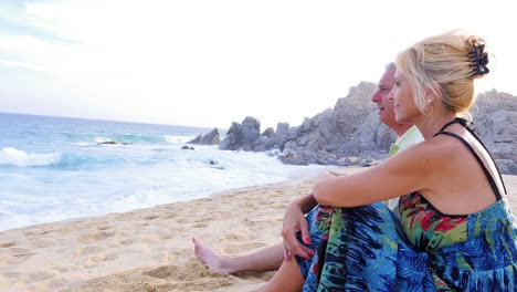 An-older-couple-sitting-on-the-beach-and-watching-the-waves