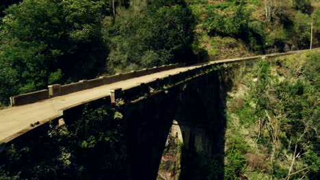 Auto-fährt-durch-eine-alte-Brücke-in-eine-erstaunliche-Landschaft-in-Madeira.