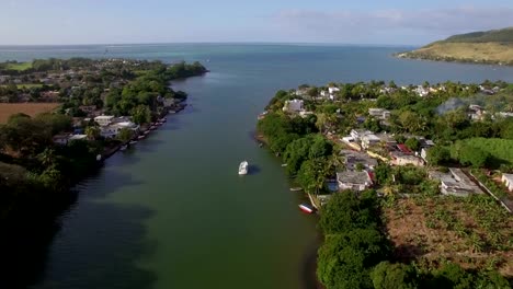 Mauritius-coastal-town-and-river-falling-into-ocean,-aerial-view