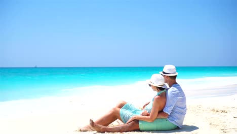 Junges-Paar-am-weißen-Strand-während-der-Sommerferien.-Glücklich-Liebhaber-genießen-ihre-Flitterwochen.