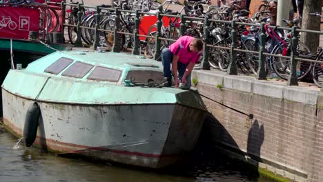 Ein-Mann,-die-Aufhebung-seines-Bootes-aus-Andocken-auf-der-Seite