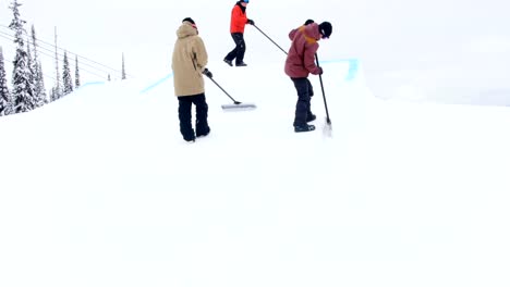 Gruppe-von-Mann-Reinigung-Schnee-im-Skigebiet