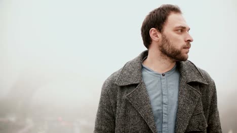 Hombre-joven-pensativa-de-pie-en-el-centro,-en-la-niebla-por-la-mañana-cerca-de-la-Torre-Eiffel-en-París,-Francia-y-mirando-a-su-alrededor