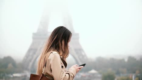 Joven-hermosa-mujer-caminando-en-el-centro-y-hablar-por-teléfono-móvil.-Mujer-cerca-de-la-Torre-Eiffel-en-París,-Francia