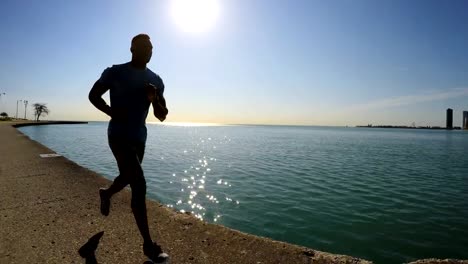 Fit-African-American-male-running-along-Chicago-shoreline