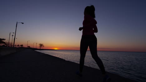 Hispanic-weibliche-Silhouette-laufen-bei-Sonnenaufgang-in-Chicago