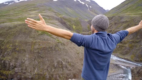 Junger-Mann-auf-Canyon-Arme-ausgestreckt-nach-dem-Glück