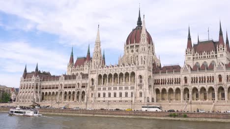 Die-ungarischen-Parlamentsgebäude-Landschaft-mit-Sightseeing-Schiff-auf-der-Donau-in-Budapest,-Ungarn-am-Nachmittag.