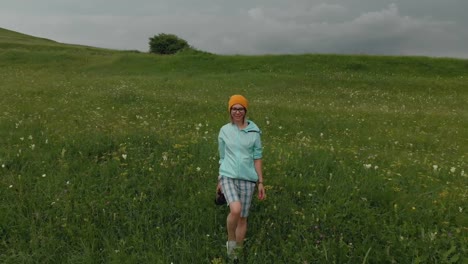 El-fotógrafo-de-la-chica-de-gafas-y-un-sombrero-camina-con-su-cámara-réflex-digital-en-el-borde-de-la-meseta-cerca-del-precipicio.-Vista-aérea