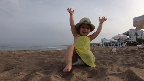 Niedliche-Mädchen-spielen-mit-Sand-am-tropischen-Strand