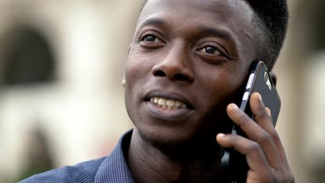 Smiling--african-man-talking-by-phone---outdoor