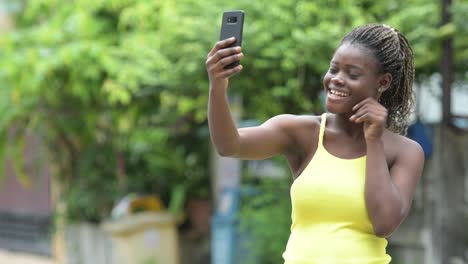 Junge-glücklich-Afrikanerin-mit-Telefon-im-freien