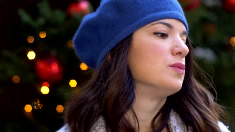 portrait-of-Pretty-young-brunette-smiling-at-camera-Christmas-tree-in-background.slow-motion