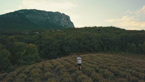 hombre-joven-camina-ocasional-en-un-campo-de-la-montaña-en-la-noche-durante-la-temporada-de-verano