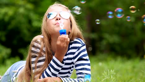 Niña-jugando-con-pompas-de-jabón-al-aire-libre.-Cámara-lenta.