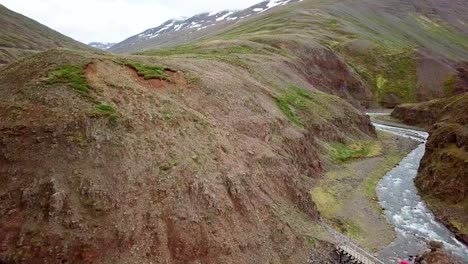 Atemberaubende-Drohne-Aussicht-auf-Mann-stehend-Arme-ausgestreckt-auf-Canyon-in-Island