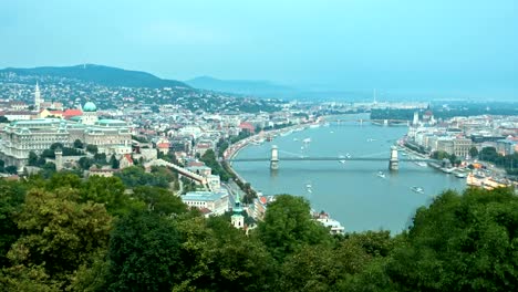 Cruise-ships-and-ferries-in-the-evening-at-the-Danube-river-in-Budapest,-Hungary.-day-to-night-time-lapse