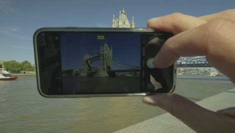 Tourist-photographing-tower-bridge-with-a-smartphone