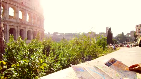 woman-looks-at-tourist-map-in-front-of-the-majestic-Colosseum-in-Rome