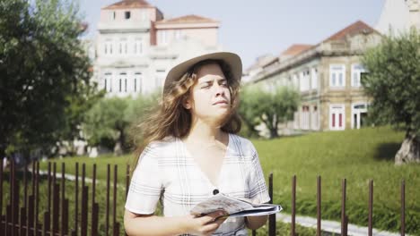 Junges-Mädchen-mit-Papierkarte-in-modernen-park