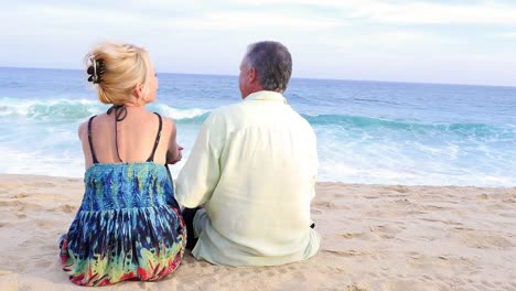 Eine-ältere-paar-sitzen-am-Strand-und-Beobachten-die-Wellen