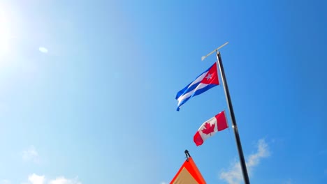 4K-Cuba-and-Canada-Flag,-Tourists-Relax-on-Tropical-White-Sand-Beach