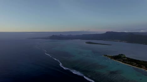 Aerial-view-of-water-line-of-seas-that-do-not-mix-against-blue-sky-with-clouds,-Mauritius-Island