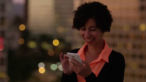 Mujer-con-teléfono-en-la-noche-en-la-ciudad-de