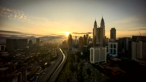 timelapse-4k-footage-of-a-beautiful-sunrise-night-to-day-of-Kuala-Lumpur-city-view-from-rooftop-of-a-building-sunset-day-to-night-of-Kuala-Lumpur-city-view-from-rooftop-of-a-building-with-moving-vehicle-and-clouds.