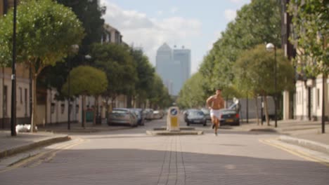 Un-joven-corriendo-aunque-Londres-con-ciudad-de-Londres-detrás-de-él.