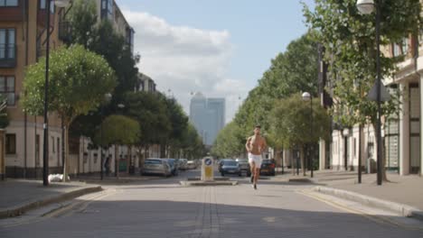 Un-joven-corriendo-aunque-Londres-con-ciudad-de-Londres-detrás-de-él.