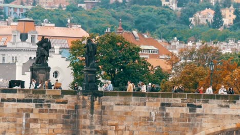 Puente-de-Carlos-de-Praga-sobre-el-río-Vltava,-en-el-cual-las-muchedumbres-de-turistas-pasear