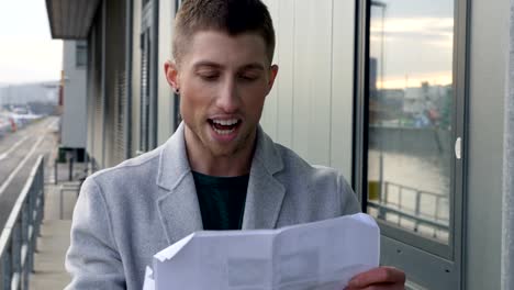 Man-Reading-Paper-Printout-Outdoors