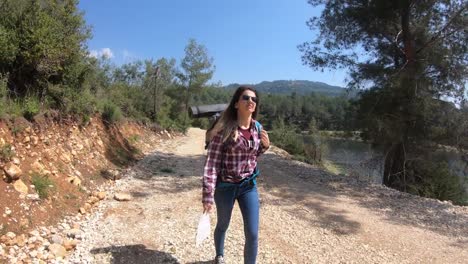 Llamaradas-de-mujer-mochila-senderismo-en-la-cima-de-una-montaña-con-el-sol.-Aventura-en-la-naturaleza.