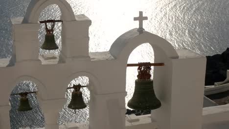 close-up-pan-of-four-church-bells-at-oia,-santorini