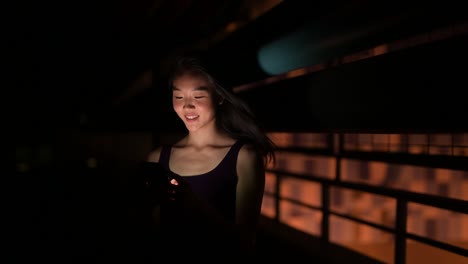 Beautiful-Asian-Woman-Outdoors-At-Night-Using-Mobile-Phone