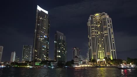 Centro-de-negocios-en-edificios-High-Rise,-noche-en-la-orilla-del-río.-rascacielos